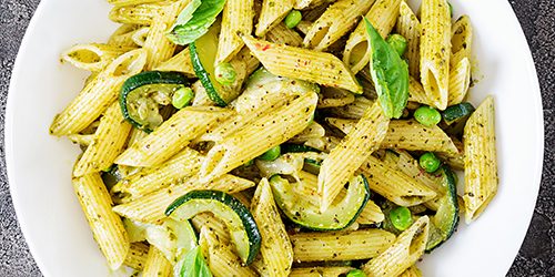 Penne pasta with  pesto sauce, zucchini, green peas and basil. I