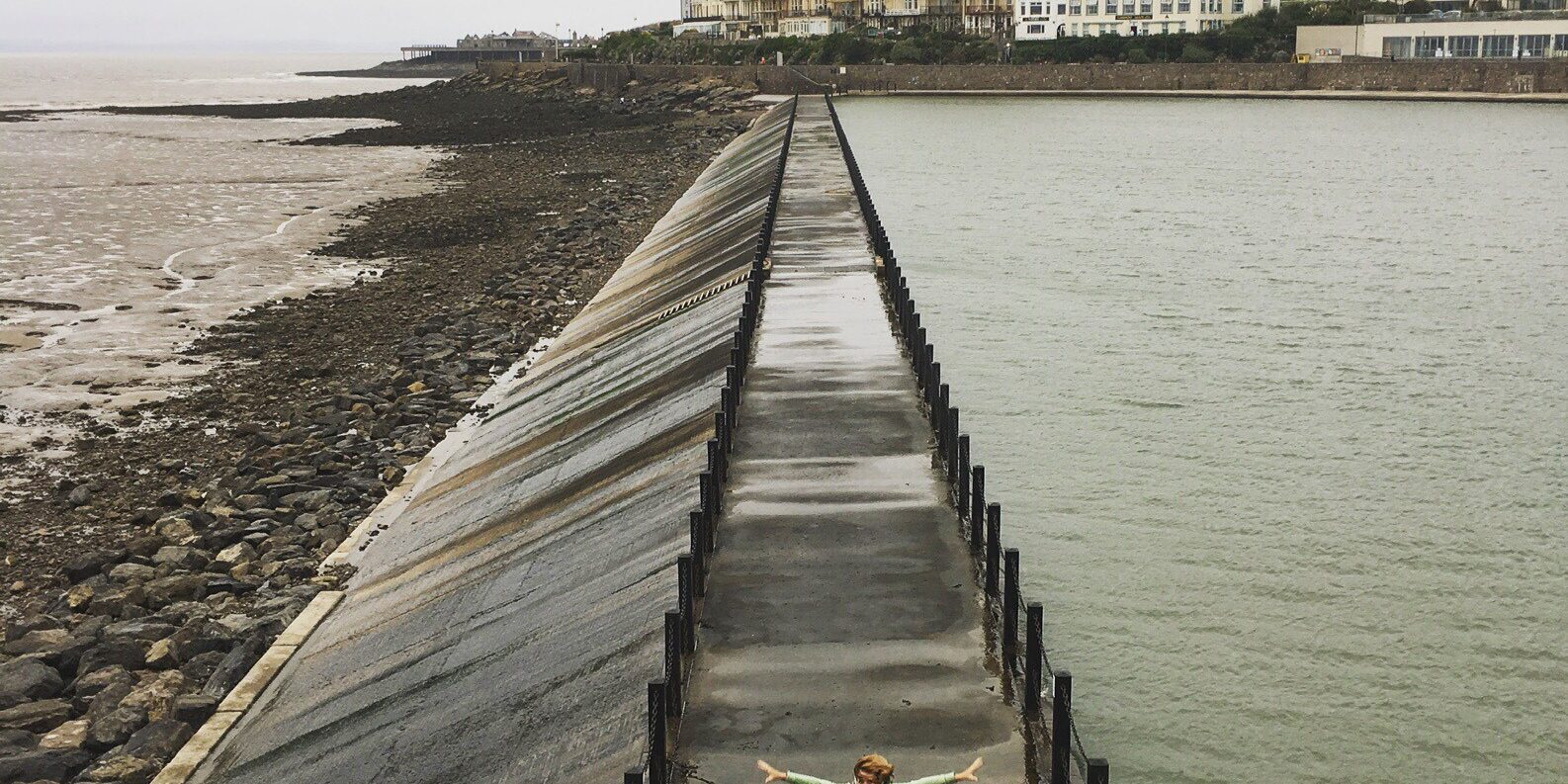 Liz standing on a walkway in between the sea and reservoir