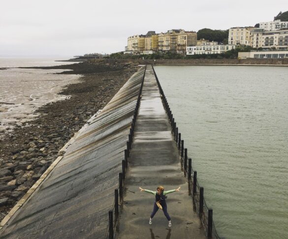 Liz standing on a walkway in between the sea and reservoir