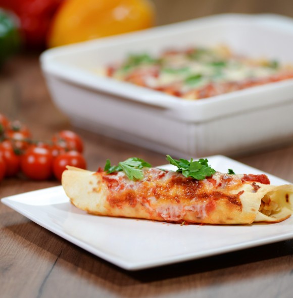 Traditional mexican enchiladas with chicken meat, spicy tomato sauce and cheese on a plate. Mexican cuisine. Traditional mexican enchiladas with chicken meat, spicy tomato sauce and cheese on a plate. Mexican cuisine