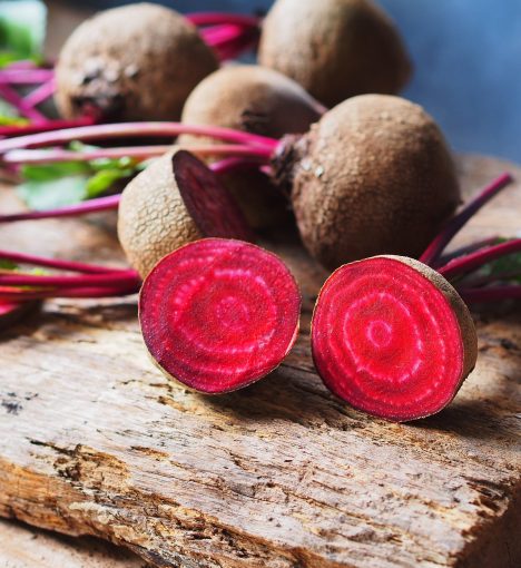 Cut in half of fresh beetroot on rustic wooden table for healthy food or vegetables concept.