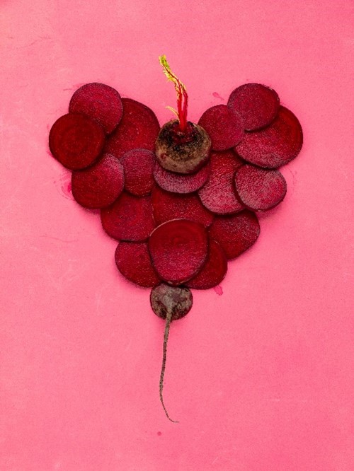 beets in the shape of a heart on a pink background