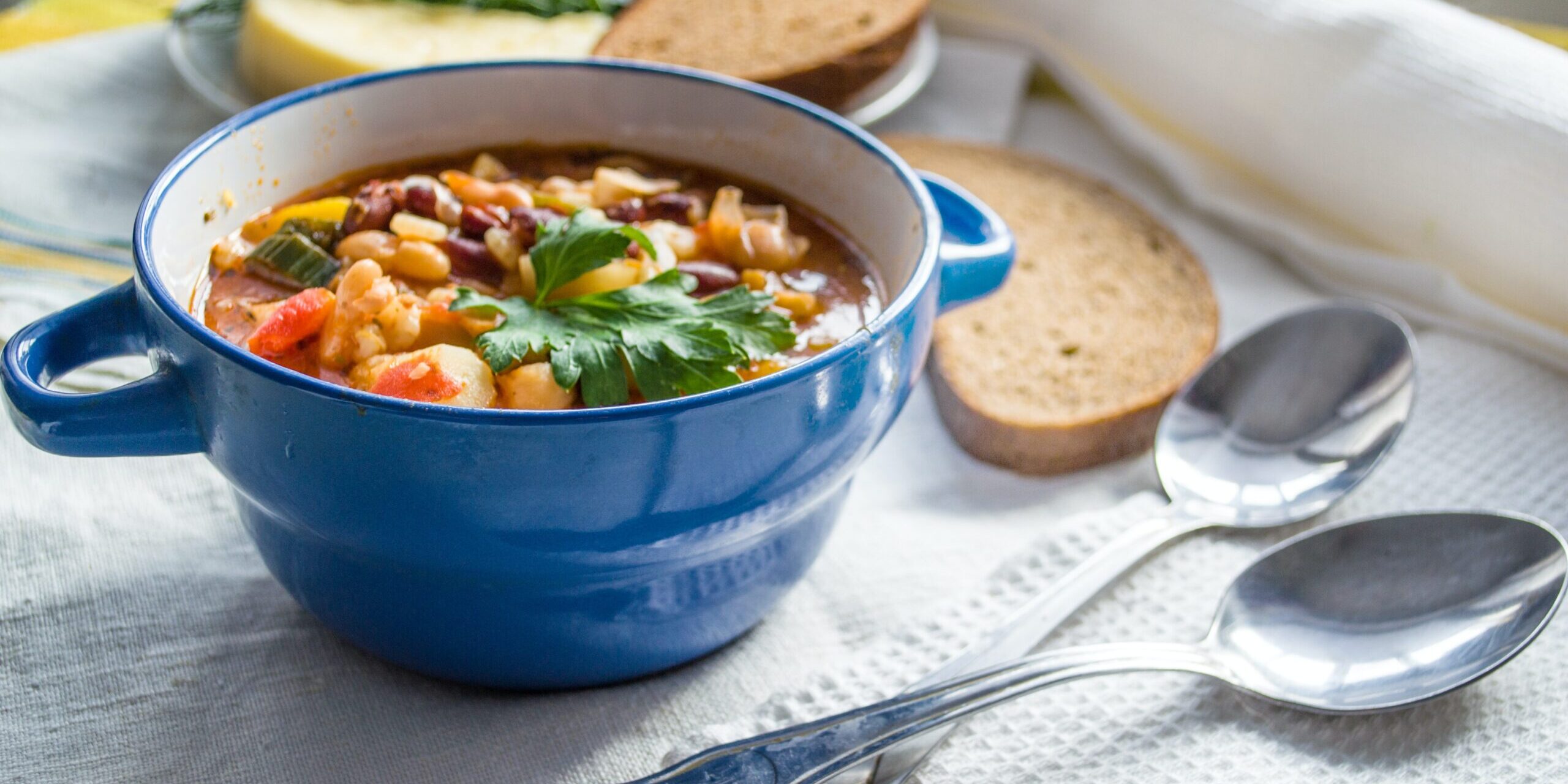 soup in a bowl on a table with a side of bread