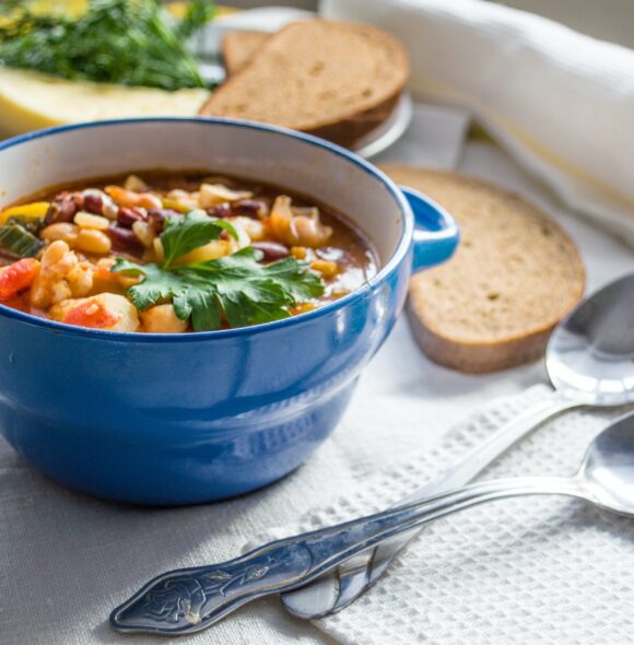 soup in a bowl on a table with a side of bread