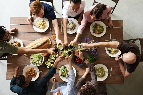 People sat round a table enjoying food