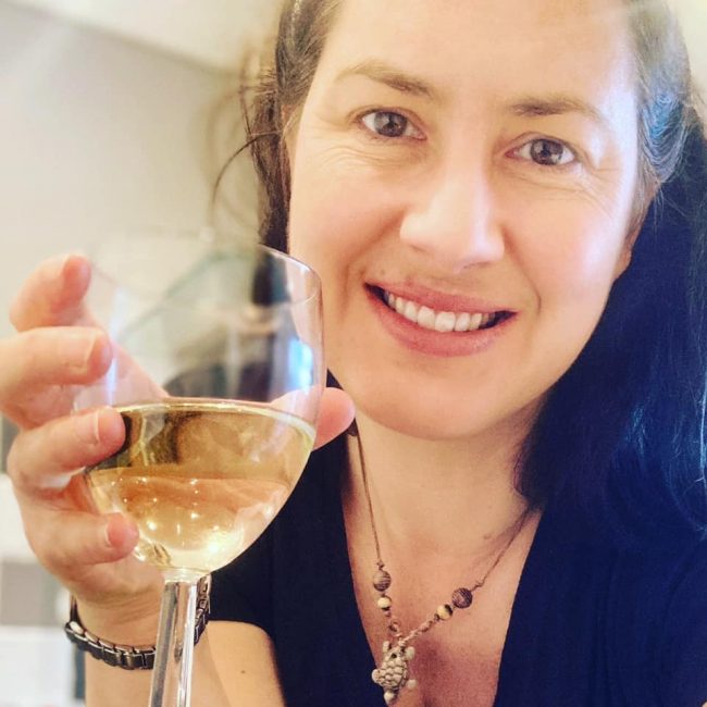 Emma Emma holding a glass of wine
