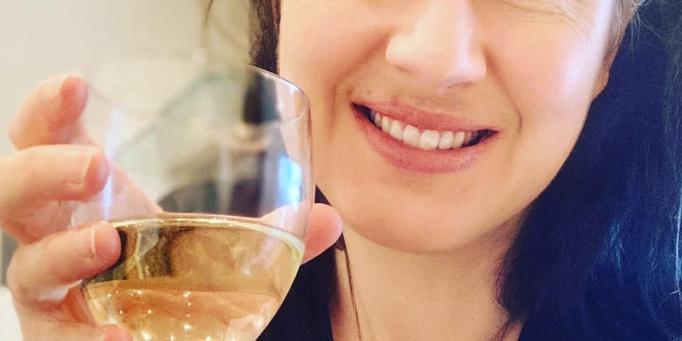 Emma Emma holding a glass of wine