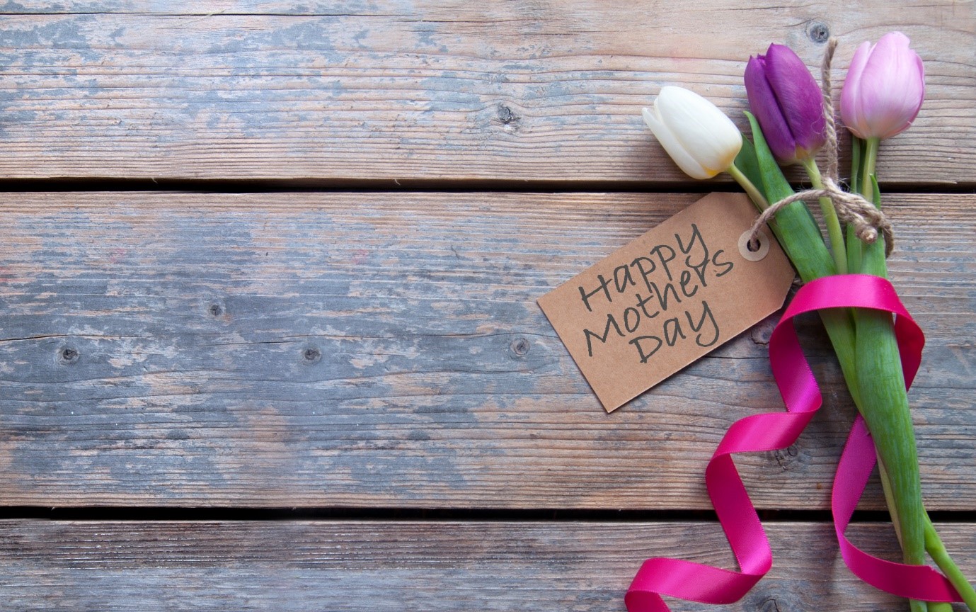 Bunch of flowers on a table with a others day label