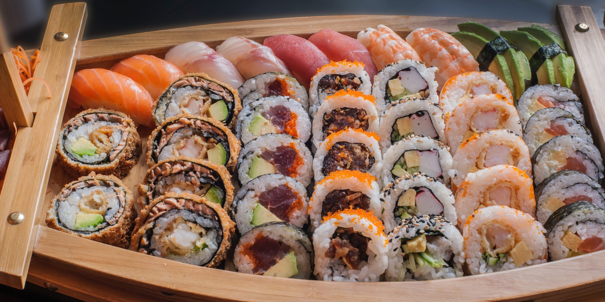 a variety of sushi in a small boat like platter