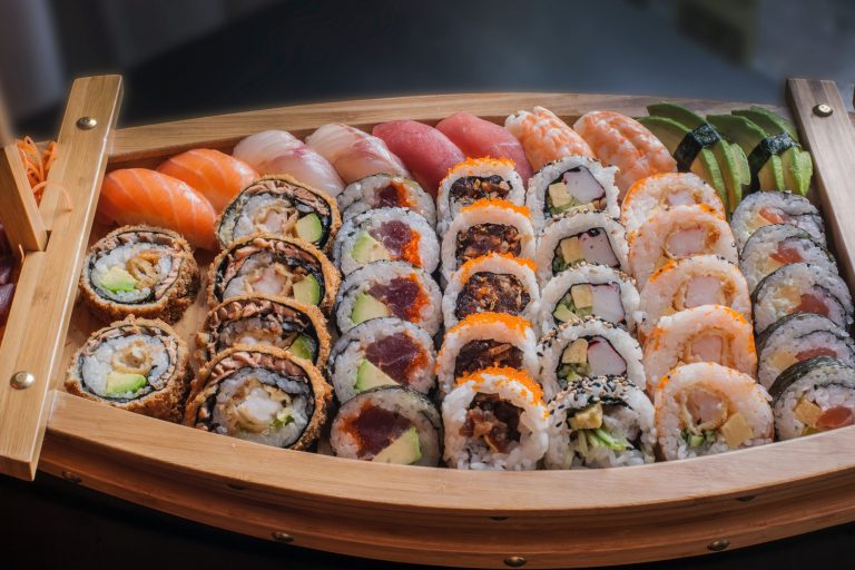 a variety of sushi in a small boat like platter