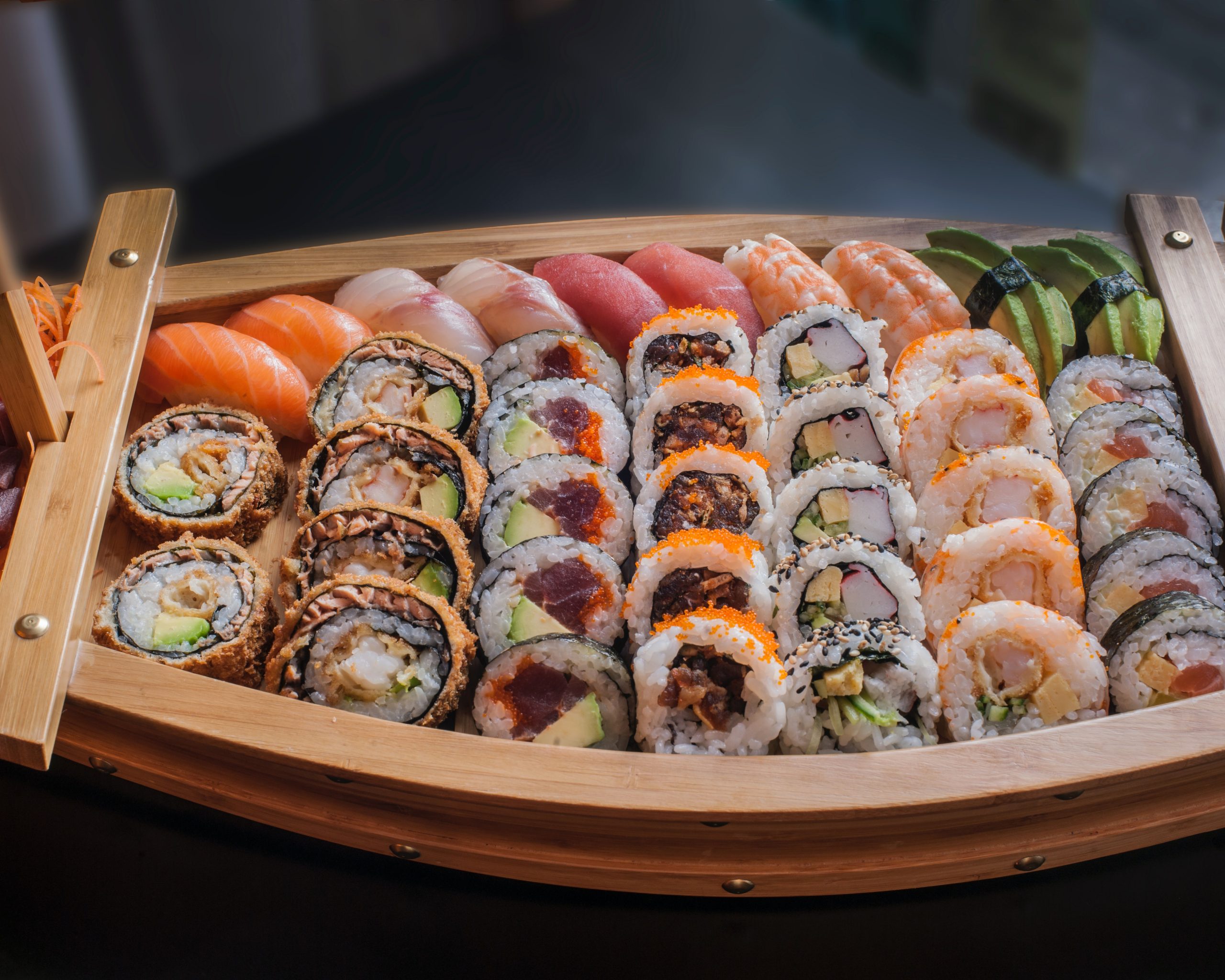 a variety of sushi in a small boat like platter