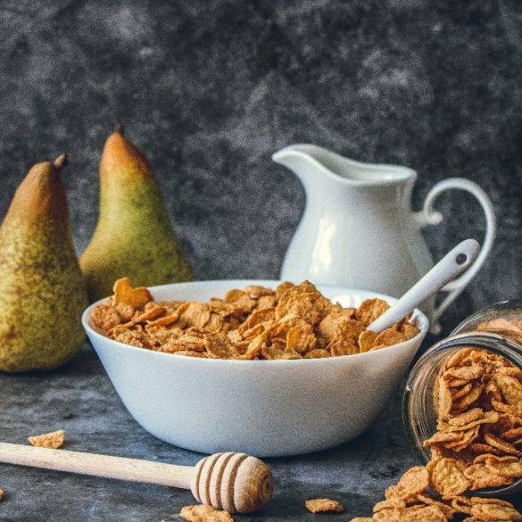 cereal cereal in a bowl with a jug and two pears next to the bowl