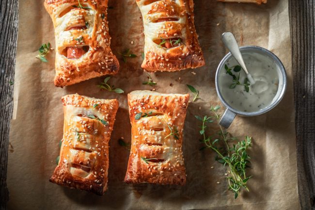Tasty and fresh sausage roll with herbs and sesame seeds