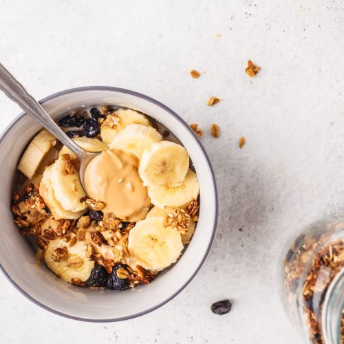 Baked granola with raisins, banana and peanut butter. Plant based diet food.