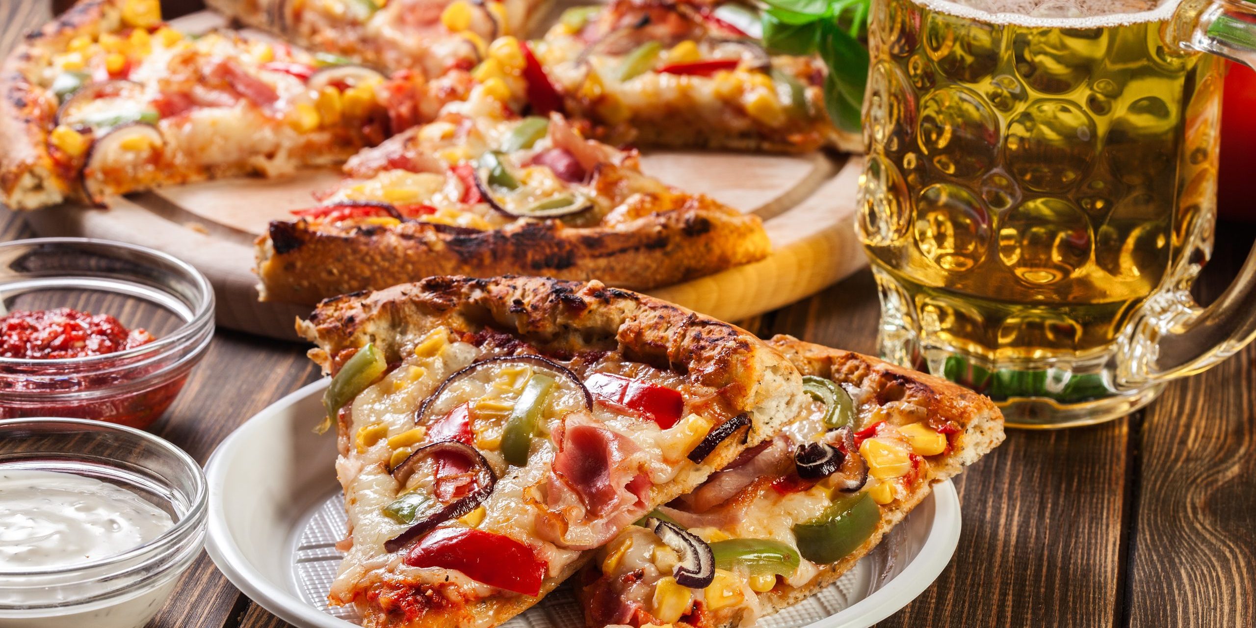 Slices of pizza with bacon, paprika and corn