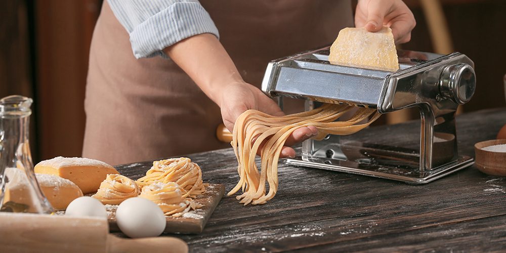 Woman preparing pasta in kitchen, closeup