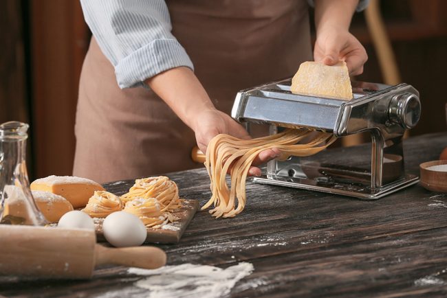 Woman preparing pasta in kitchen, closeup