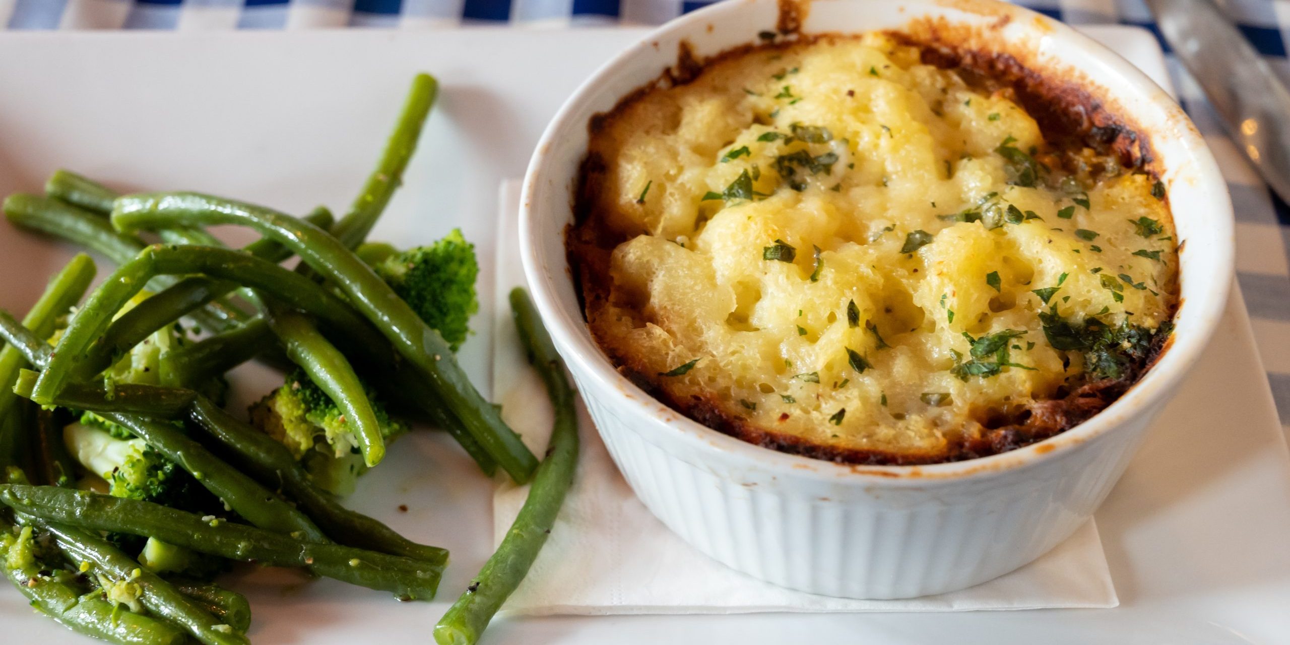 Seasoned Lentils and mushrooms pie slow cooked in red wine, topped with.cheddar mash and served with seasonal vegetables