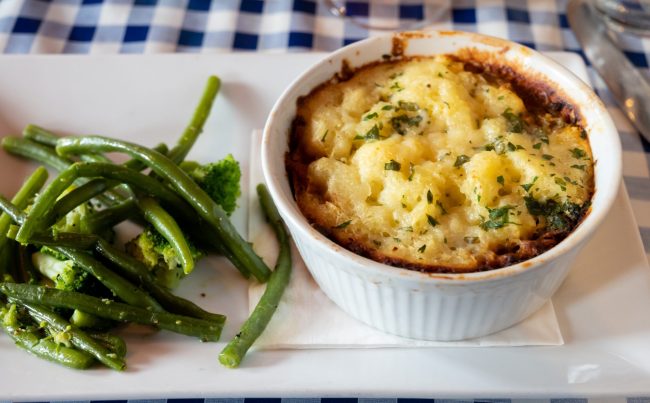 Seasoned Lentils and mushrooms pie slow cooked in red wine, topped with.cheddar mash and served with seasonal vegetables