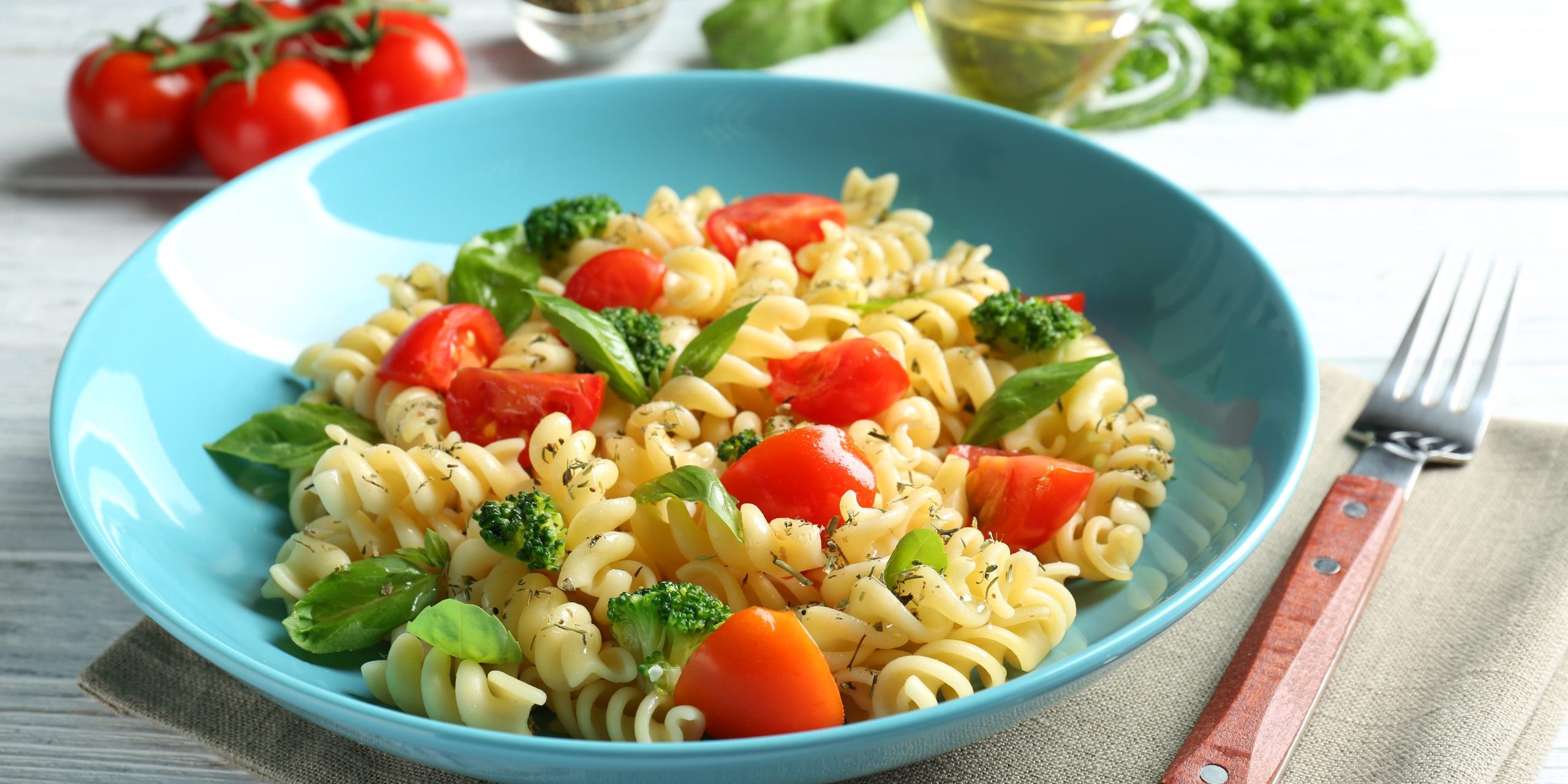 Plate of pasta salad with tomatoes and broccoli