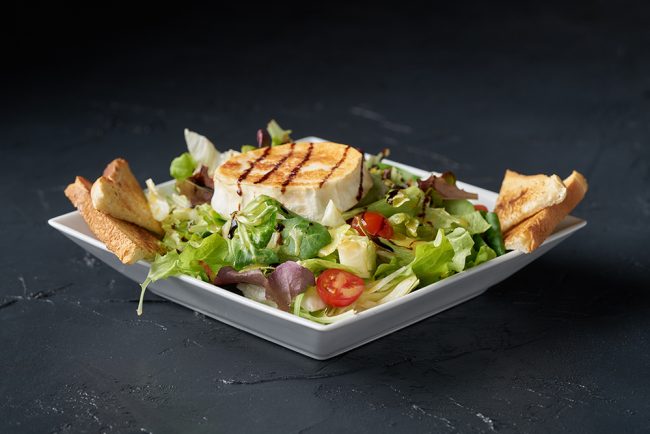 Fresh green healthy salad with grilled goat cheese chevre isolat