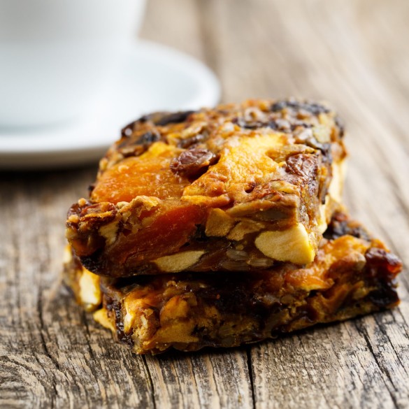 Tasty vegetarian granola cake slice with coffee on wooden table. Delicious vegetarian granola cake slice on wooden table.