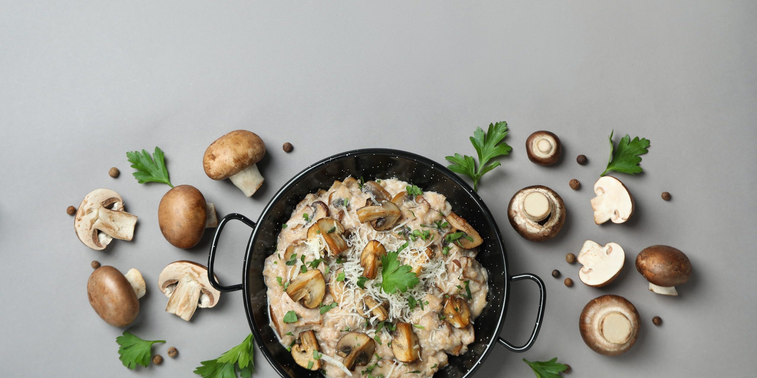 Concept of tasty food with risotto with mushrooms on gray backgr