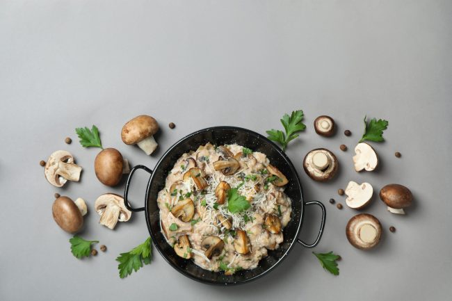 Concept of tasty food with risotto with mushrooms on gray backgr