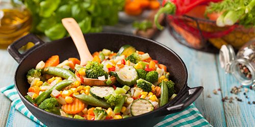 Mix of vegetables fried in a wok.