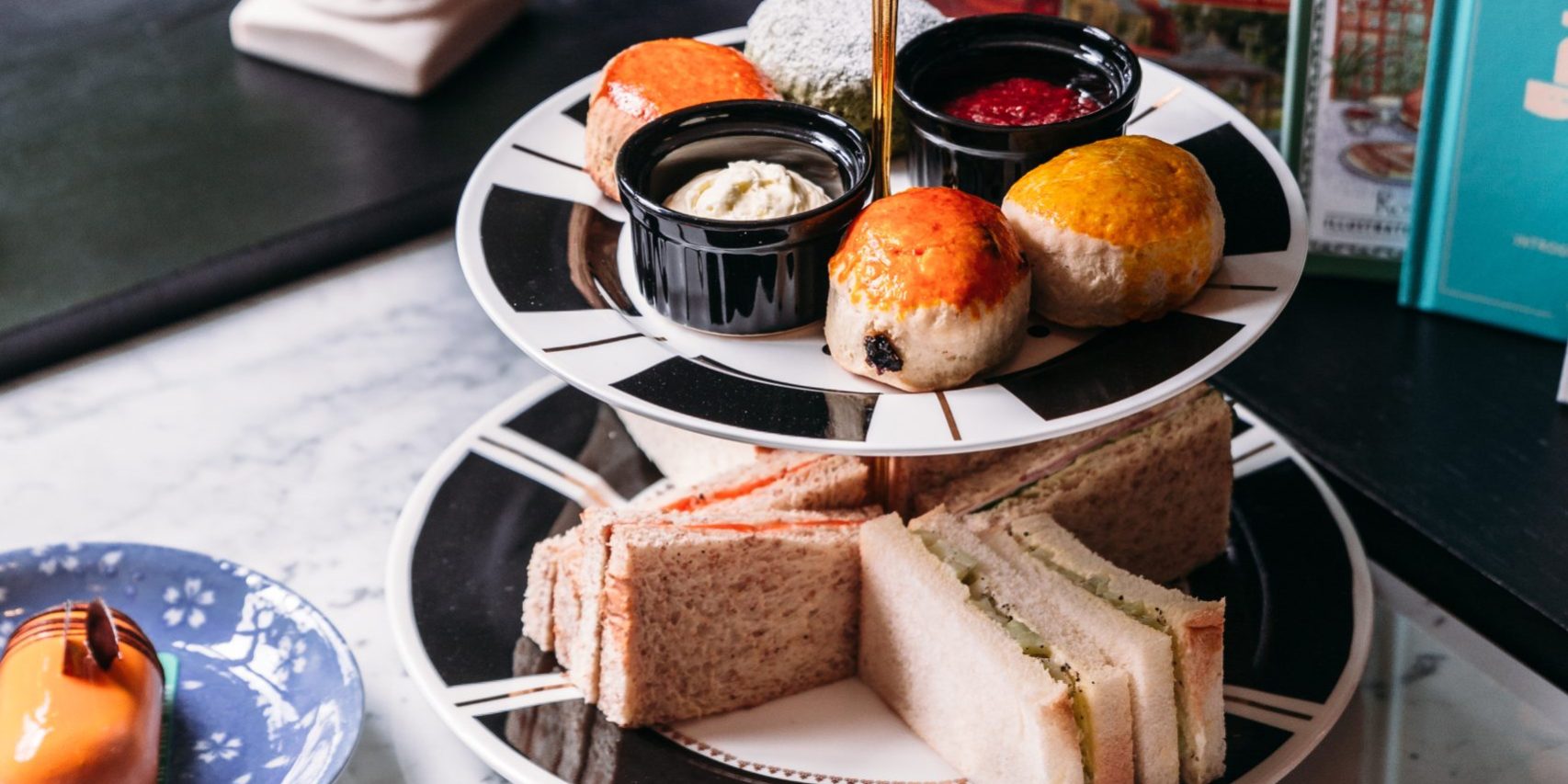 English afternoon tea set including hot tea, pastry, scones, san