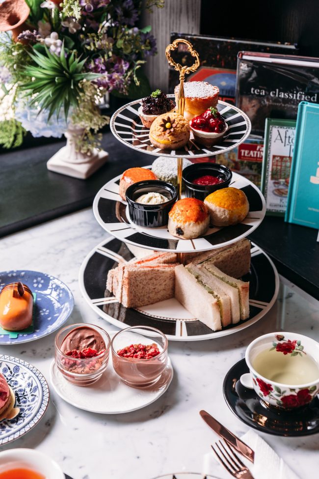 English afternoon tea set including hot tea, pastry, scones, san