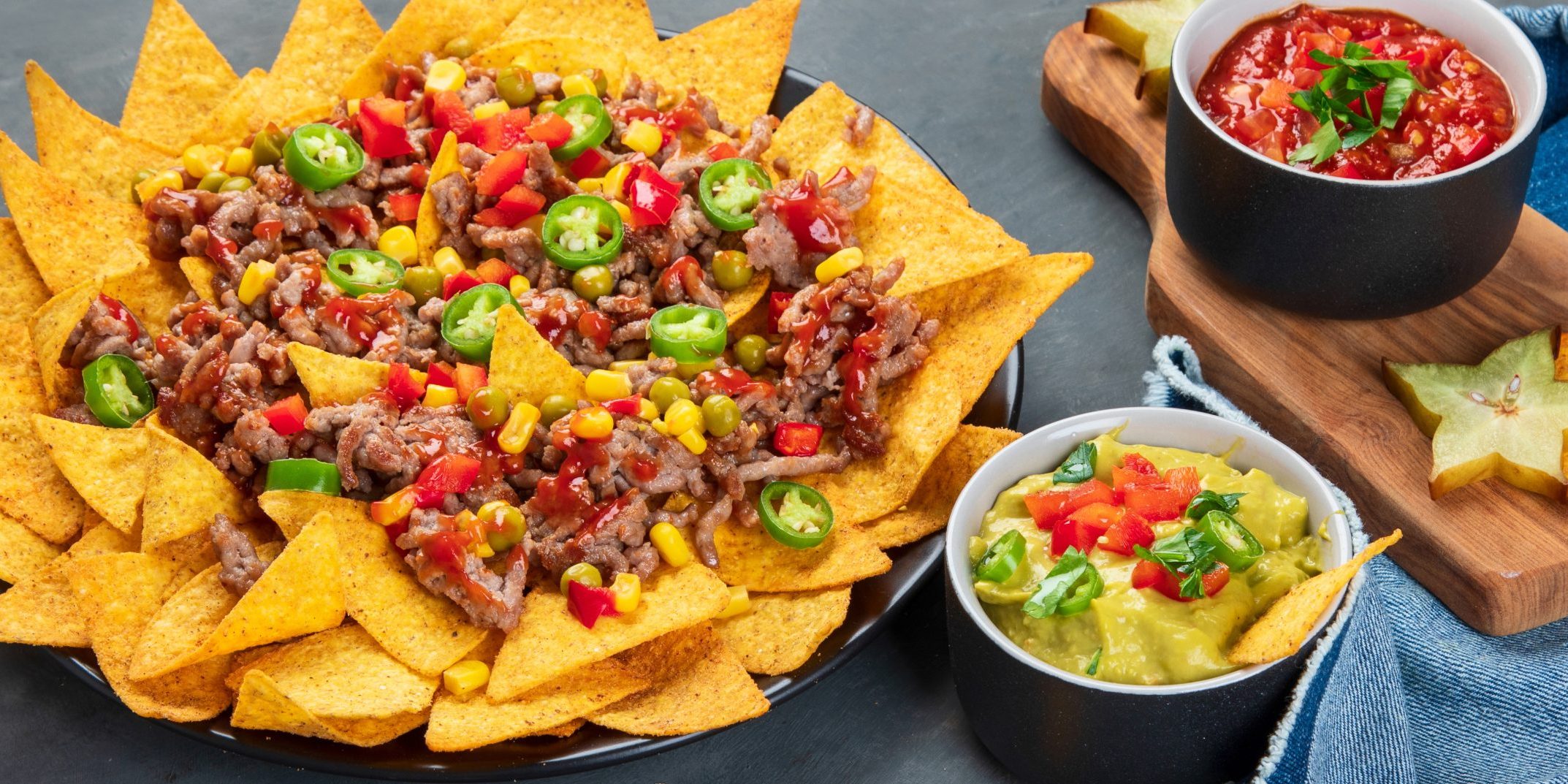 Hispanic mexican food, nachos with meat, corn and halapenjo on d