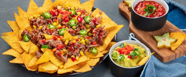 Hispanic mexican food, nachos with meat, corn and halapenjo on d