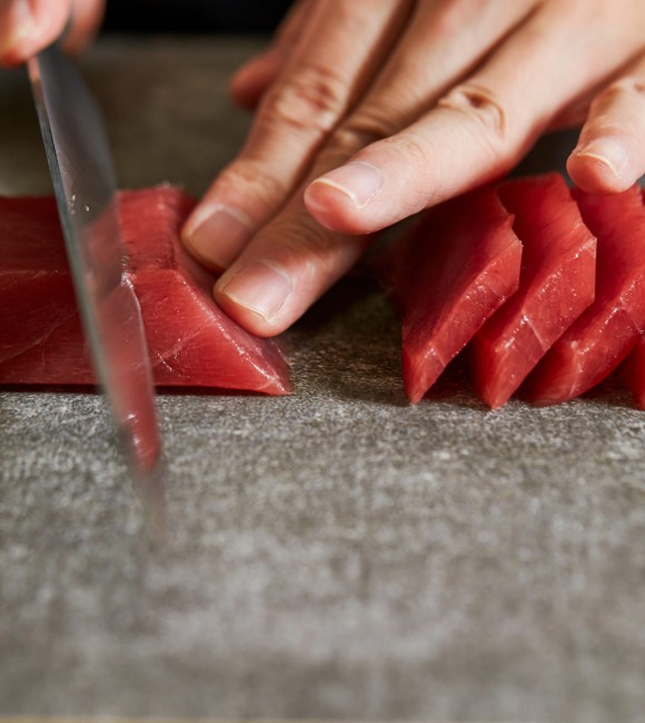 Slicing tuna saku block with sashimi knife Slicing tuna saku block with sashimi knife