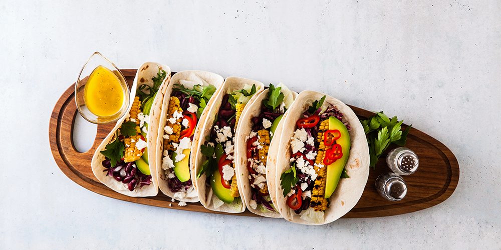 Vegetarian snack tacos with grilled vegetables, avocado, feta ch