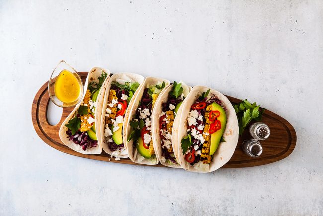 Vegetarian snack tacos with grilled vegetables, avocado, feta ch