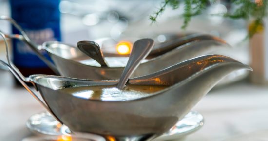 detailed shot of luxury silver gravy bowls containing salad dres