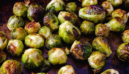 Roasted Brussels Sprouts with Garlic Butter on a Sheet Pan: Brussels sprouts that have been baked in garlic butter on a rustic baking pan