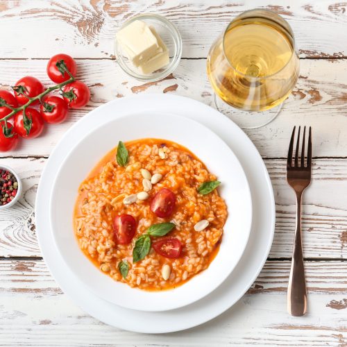 Plate with tasty risotto on wooden table