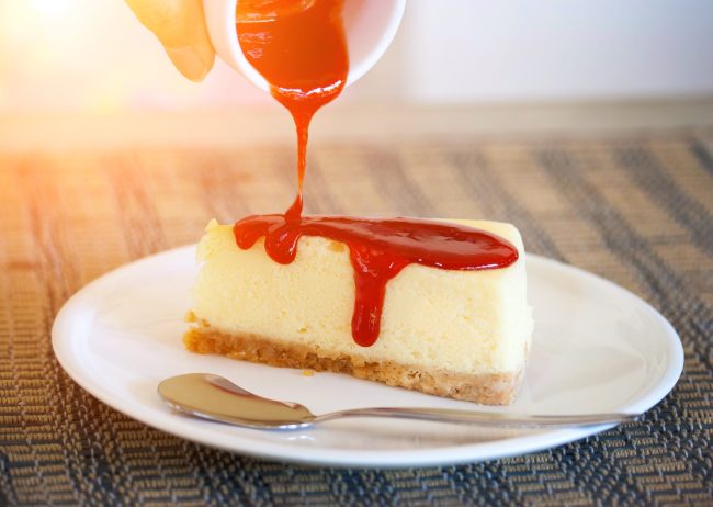 Pour strawberry sauce into cheesecake