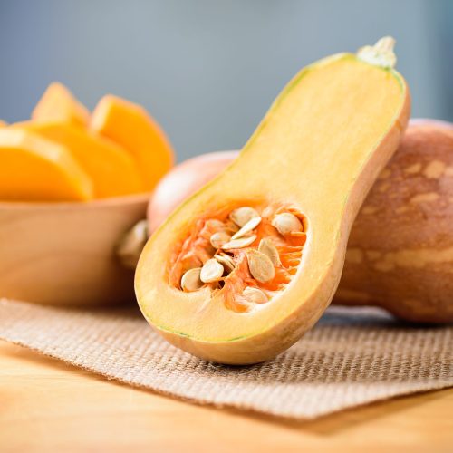 Half and slice butternut squash in a bowl for cooking