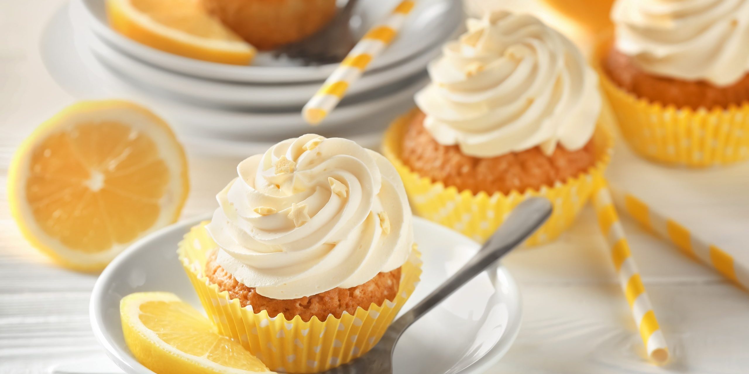 Plate with delicious lemon cupcake on white table