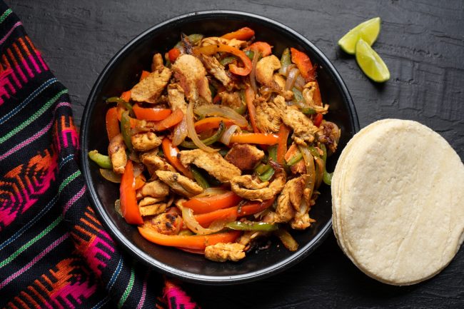 Mexican chicken fajitas on dark background