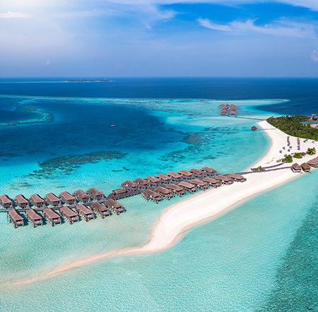 Panoramic aerial view of a turquoise colored lagoon with a tropi