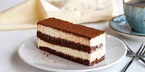 Tiramisu dessert on a white background. Italian sweet dessert concept. Plate of tiramisu cake. close up. selective focus. Horizontal view.