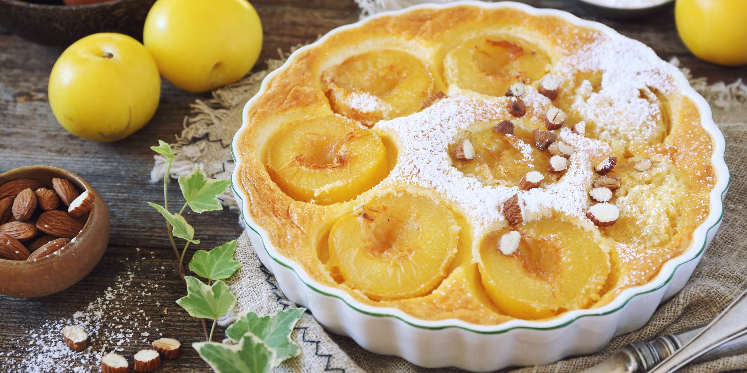 Yellow plums clafoutis (flan) with almonds, icing sugar dressing