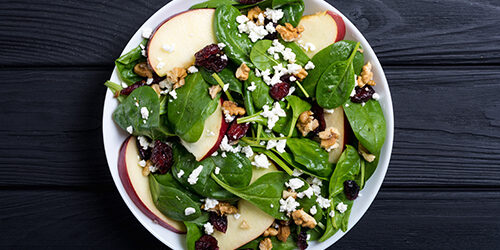 Autumn spinach salad with apple , cheese , walnut and dried cran
