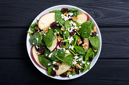 Autumn spinach salad with apple , cheese , walnut and dried cran