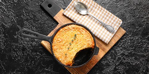 Frying pan with tasty Shepherd’s pie on black background