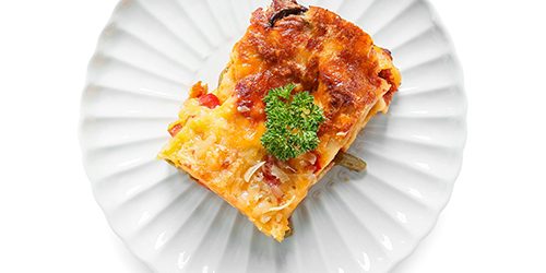 Plate with tasty vegetable lasagna on white background